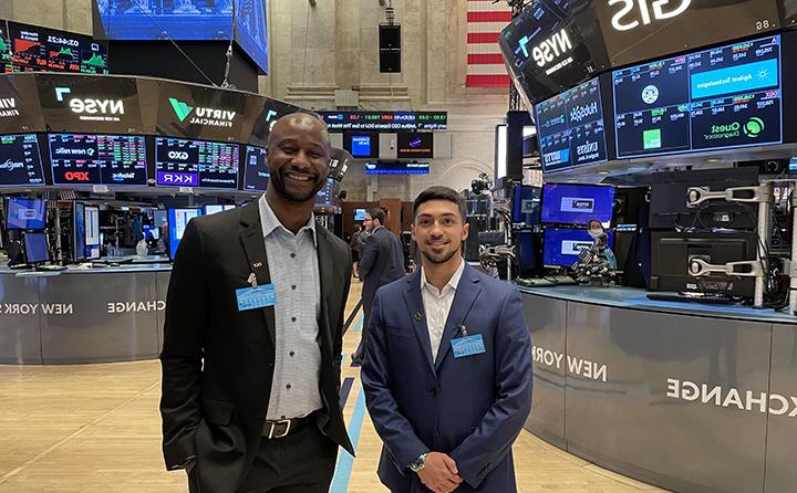 23岁的Ryan Rivera(左)和Dr. 基督教Nsiah (right) on the floor of the New York Stock Exchange.